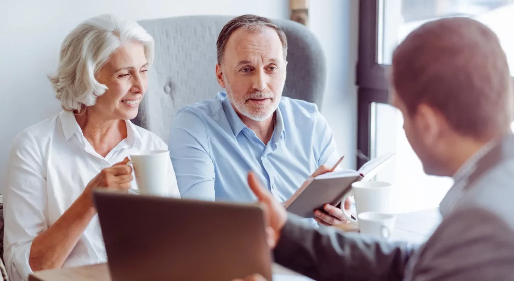 Couple senior en rendez-vous de conseil et de prévoyance avec un professionnel.